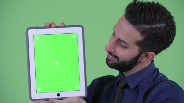 Счастливый молодой бородатый персидский бизнесмен показывает цифровой планшет — стоковое видео