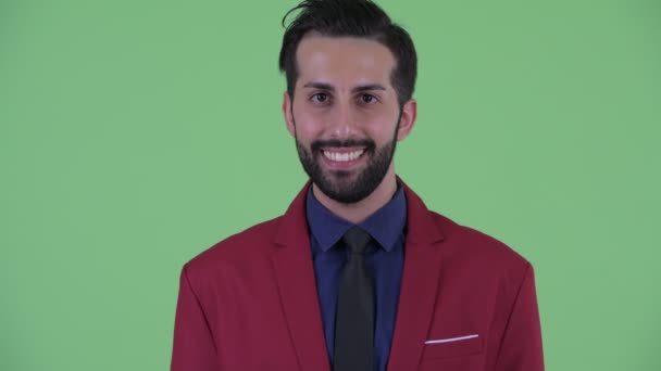 Face of happy young bearded Persian businessman in suit smiling — Stock Video