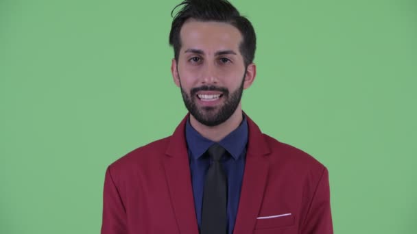 Face of happy young bearded Persian businessman in suit talking — Stock Video