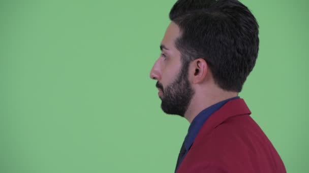 Vista del perfil de primer plano de feliz joven barbudo empresario persa en traje de hablar — Vídeos de Stock