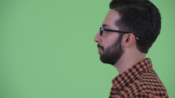 Vista del perfil de primer plano del joven y feliz barbudo hipster persa hablando — Vídeos de Stock