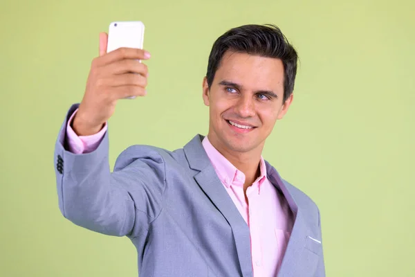 Portrait de heureux jeune homme d'affaires beau prenant selfie — Photo