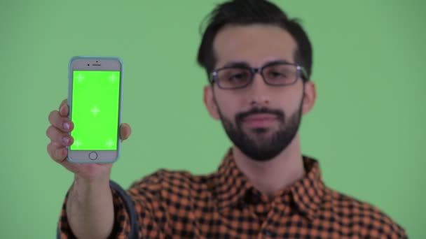 Volto di felice giovane barbuto hipster persiano uomo che mostra il telefono — Video Stock