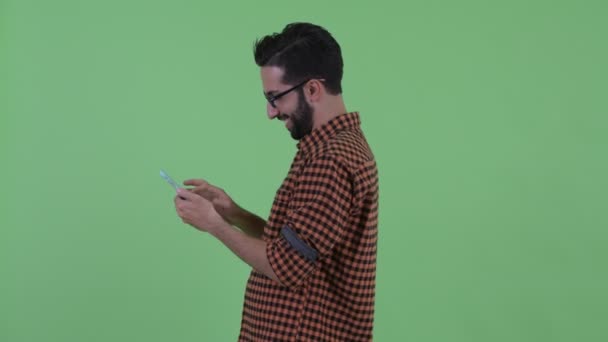 Vue du profil de jeune homme barbu perse hipster avec téléphone enlevé — Video