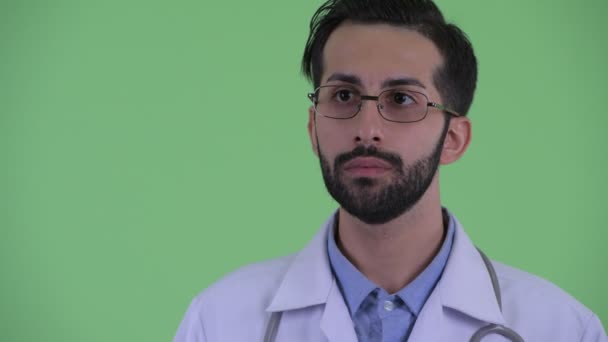 Face of happy young bearded Persian man doctor thinking — Stock Video