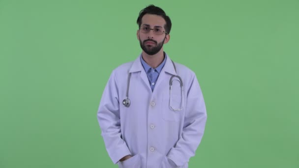 Happy Young bebaarde Perzische man arts glimlachend met armen gekruist — Stockvideo