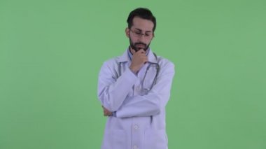 Stresli genç sakallı Pers adam doktor düşünme ve aşağı bakıyor