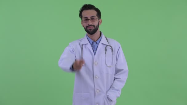 Щаслива молода Бородаті Перська людина лікар вказуючи на камеру — стокове відео