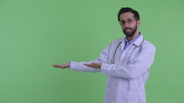 Hangsúlyozta, fiatal szakállas perzsa férfi orvos mutat valamit — Stock videók