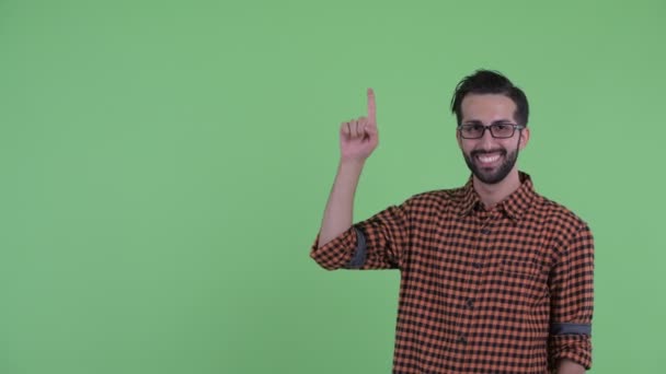 Heureux jeune homme barbu perse hipster parler et pointant vers le haut — Video