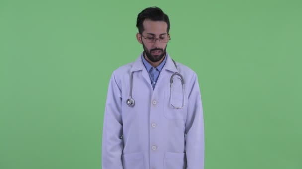 Стресс молодой бородатый персидский врач делает большие пальцы вниз — стоковое видео