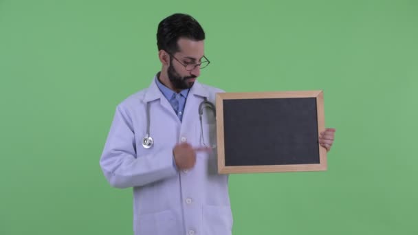 Lycklig ung skäggiga Persiska mannen Doctor Holding Blackboard och ge tummen upp — Stockvideo