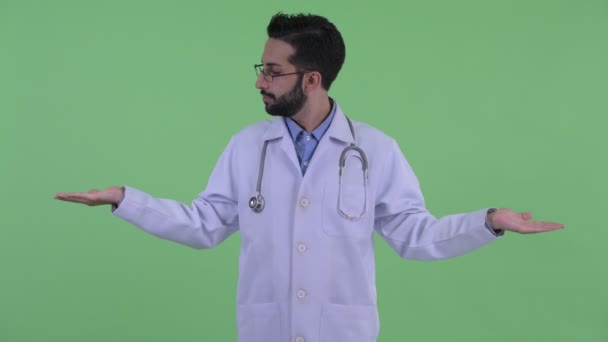 Boldog fiatal szakállas perzsa férfi orvos képest valami — Stock videók