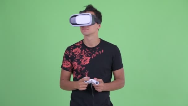 Jovem homem bonito feliz jogando jogos e usando fone de ouvido realidade virtual — Vídeo de Stock