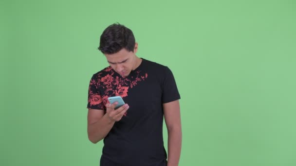 Šťastný mladý pohledný muž pomocí telefonu a získání dobré zprávy — Stock video