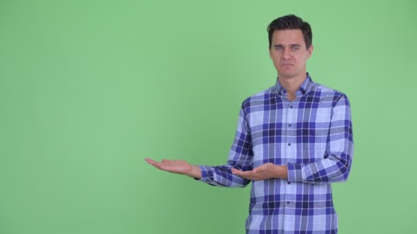 Estressado jovem hipster homem mostrando algo e dando polegares para baixo — Vídeo de Stock