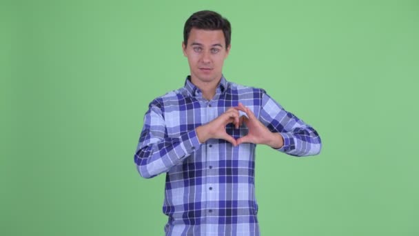 Boldog fiatal csinos csípő ember-val odaad szív gesztus — Stock videók