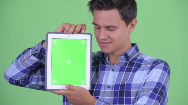 Лицо счастливого молодого красивого хипстера, показывающего цифровой планшет — стоковое видео