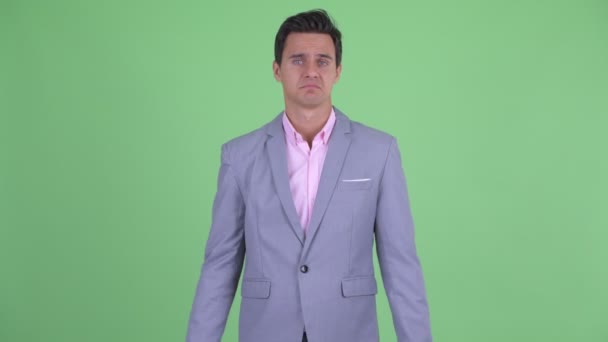 Verwirrter junger gutaussehender Geschäftsmann zuckt mit den Schultern — Stockvideo