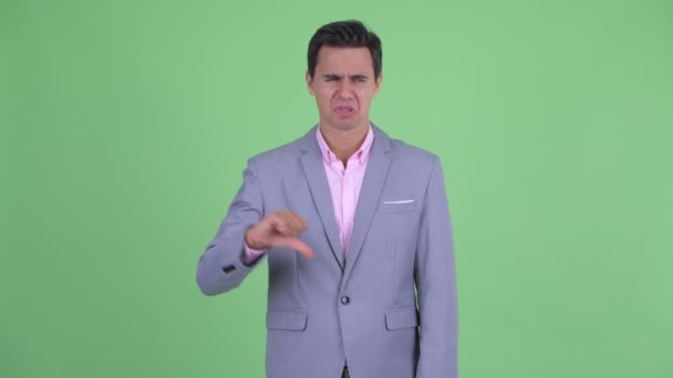 Sad young businessman giving thumbs down — Stock Video