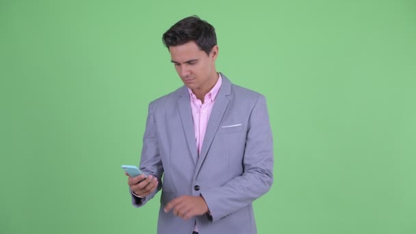 Щасливий молодий красивий бізнесмен використовує телефон і отримує хороші новини — стокове відео