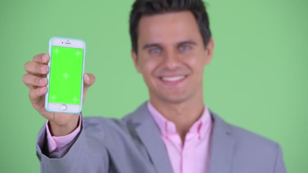 Tvář šťastný mladý pohledný podnikatel zobrazeno telefon — Stock video