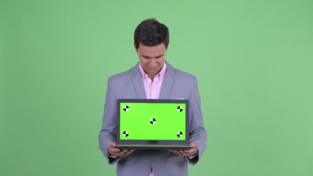 Glücklich junge hübsche Geschäftsmann denken, während sie Laptop zeigen — Stockvideo