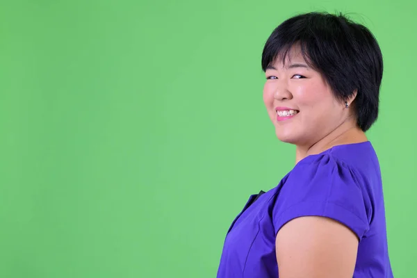 Primer plano vista del perfil de la joven mujer asiática feliz con sobrepeso mirando la cámara —  Fotos de Stock