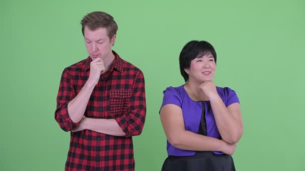 Szczęśliwy z nadwagą Asian kobieta z podkreślił skandynawski Hipster człowiek myśląc razem — Wideo stockowe