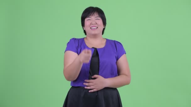 Щаслива молода надмірна вага Азіатська жінка сміятися і вказуючи на камеру — стокове відео