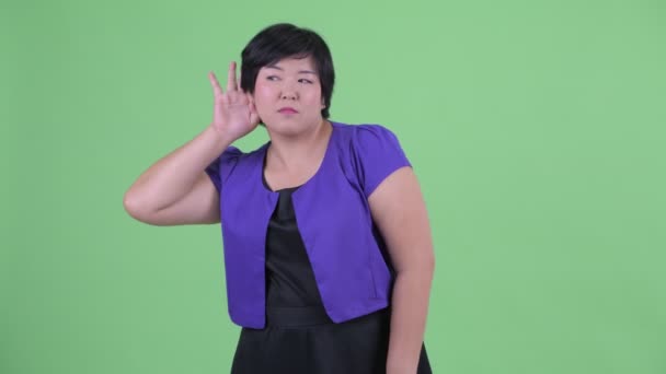 幸せな若い太りすぎのアジアの女性が聞いて笑う — ストック動画