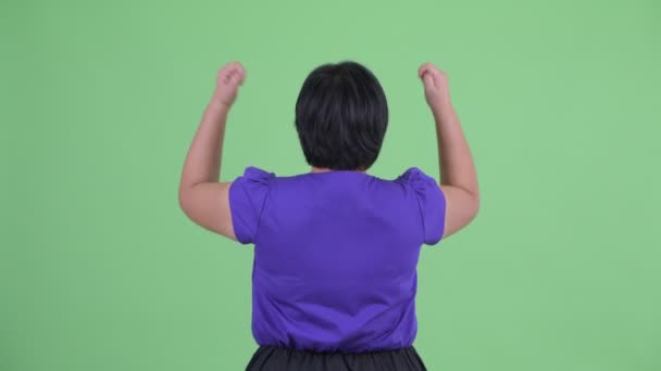 Bakifrån av Happy Young övervikt asiatisk kvinna med nävar upp — Stockvideo