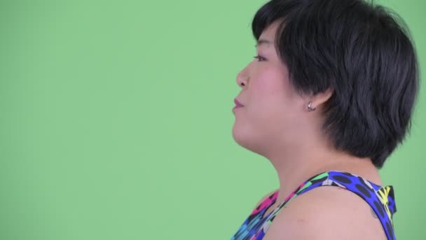 Primo piano profilo vista di felice giovane in sovrappeso donna asiatica parlando pronto a festa — Video Stock