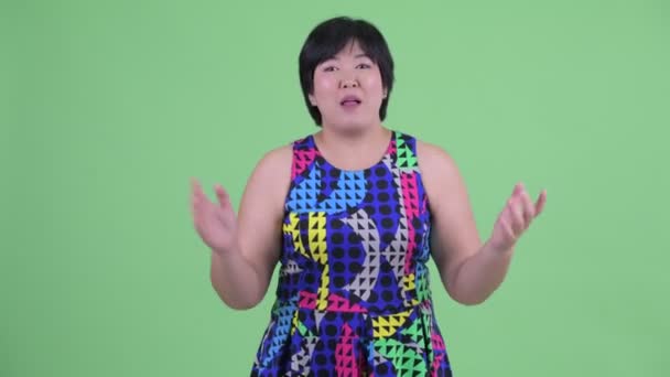 幸せな若い太りすぎのアジアの女性はパーティーの準備ができている何かを提示 — ストック動画