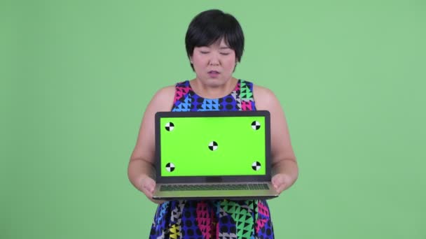 Zestresowany młody nadwaga Asian kobieta pokazując laptop — Wideo stockowe