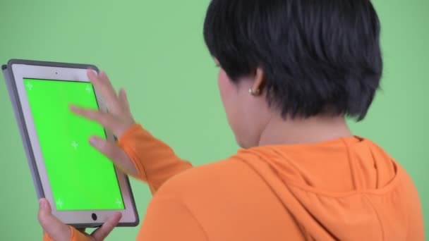Primer plano vista trasera de feliz joven mujer asiática con sobrepeso utilizando tableta digital listo para el gimnasio — Vídeo de stock