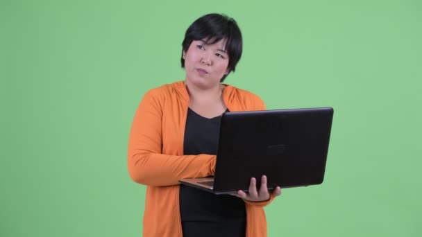 Spor salonu için hazır dizüstü bilgisayar kullanırken Mutlu genç kilolu Asyalı kadın düşünme — Stok video