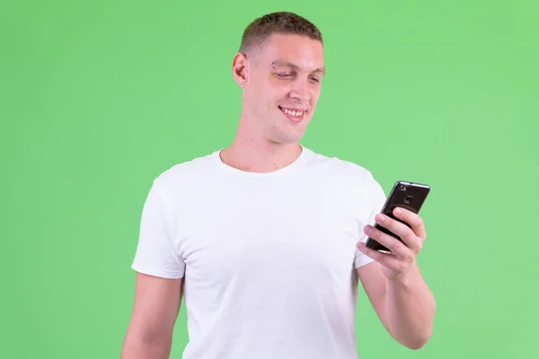 Portrét šťastného mladého muže, který používá telefon — Stock fotografie