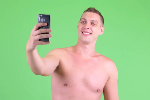 Portret van gelukkig shirtless jonge man het nemen van selfie — Stockfoto