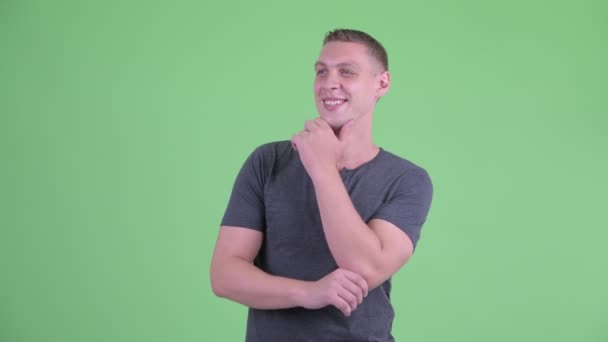Porträt eines glücklichen jungen Mannes, der denkt und aufblickt — Stockvideo