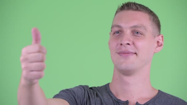 Gezicht van gelukkige jonge man geven duimen omhoog — Stockvideo