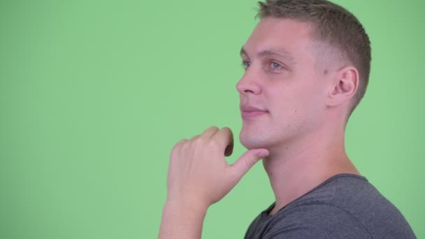 Closeup profile view of happy young man thinking — Stock Video