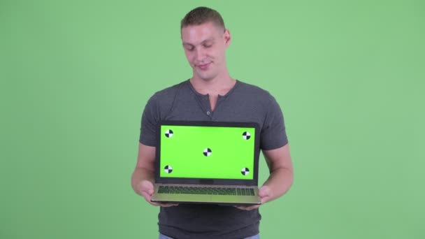 Стресс молодой человек показывает ноутбук и получает плохие новости — стоковое видео