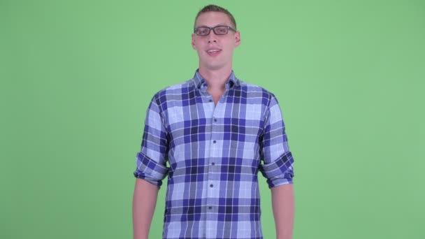 Gözlüklü mutlu genç hipster adam gülümsüyor — Stok video