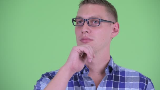 Tvář šťastného mladého hipsterského muže přemýšlejícího a vzhlížejícího — Stock video