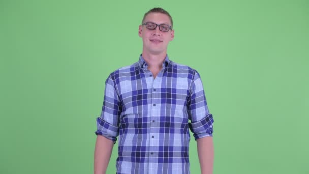 Glad ung hipster man ler med armarna korsade — Stockvideo