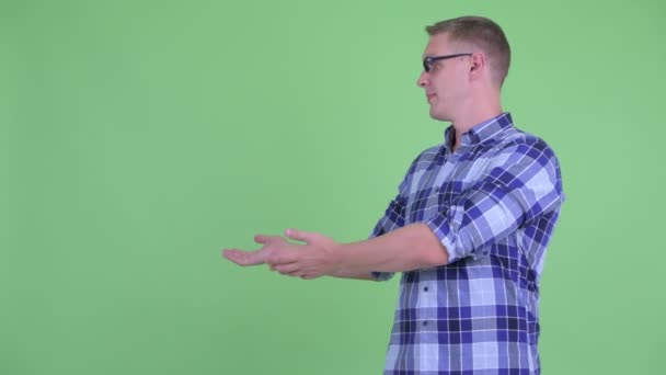 행복한 젊은 힙스터 남자 보여주는 뭔가 에 이 백 — 비디오