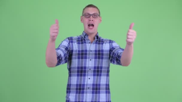Šťastný mladý hipster muž dává palce nahoru a vypadá vzrušeně — Stock video
