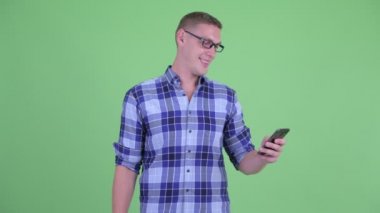 Telefon kullanırken mutlu genç hipster adam düşünme