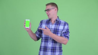 Mutlu genç hipster adam telefon gösteren ve başparmak veren